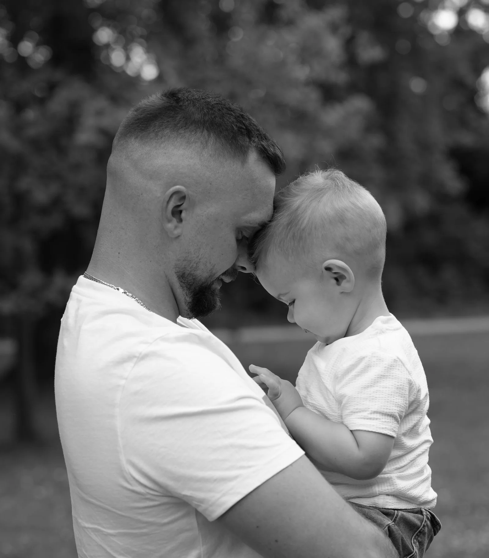 Schwarz-Weiß-Bild eines Mannes und eines kleinen Jungen, die ihre Stirnen aneinanderlegen
