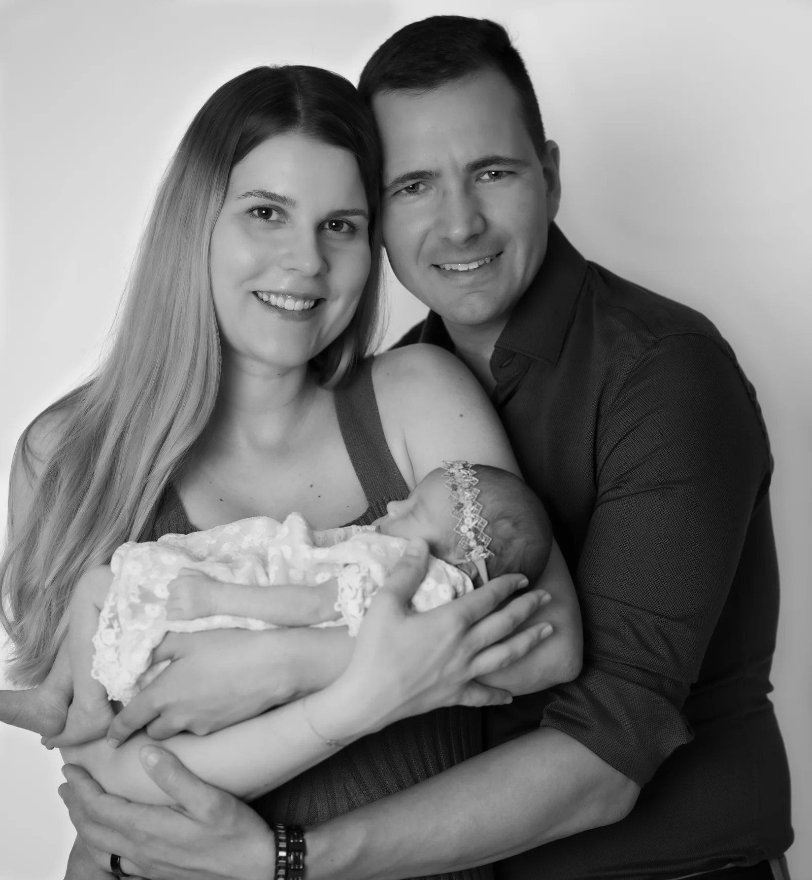 Schwarz-Weiß-Porträt eines Paares mit einem schlafenden Baby in den Armen der Frau